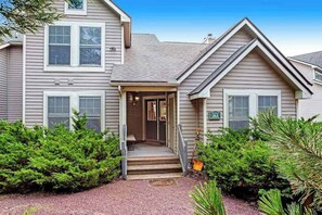 A two-story house with a front porch, a visible number '353', and a well-maintained garden with various shrubs. - Modern Townhouse with WiFi and Washer/Dryer (Tannersville)