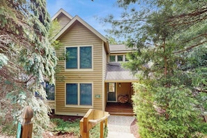 A two-story house with a front porch, a visible mailbox, and a small garden area. - Cozy Home with Wood Fireplace and Views (Tannersville)