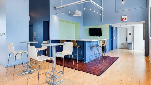 A modern bar area with high stools, a counter, and a flat-screen TV. - Downtown Chicago Stay with Free In & Out Parking-2 (Chicago)