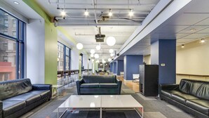 A modern lounge area with leather sofas, a central coffee table, and a projector screen. - Downtown Chicago Stay with Free In & Out Parking-2 (Chicago)