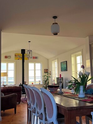 Un vaste espace de vie comprenant une table à manger, des chaises et une cheminée.