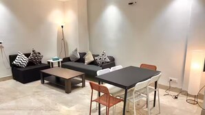 Una sala de estar moderna con un conjunto de sofá, una mesa de comedor y sillas.