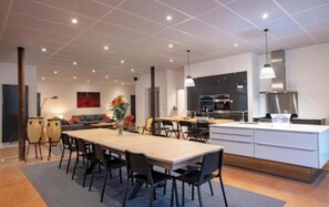 Une cuisine moderne avec un îlot central, un coin repas avec des chaises et un canapé.