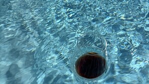 A clear pool with ripples and a single dark object at the bottom.