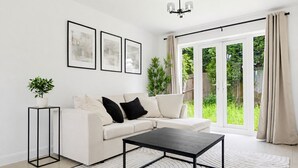 Een moderne woonkamer met een bank, salontafel en kunstwerk aan de muur.