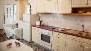 Une cuisine équipée d’un réfrigérateur, d’une cuisinière, d’un évier et d’armoires en bois.