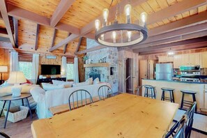 A wooden interior with a dining area, kitchen, and living room.