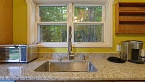 A kitchen with a stainless steel sink, a toaster, and a coffee maker. - Poconos Family Retreat | 5 Acres | Sleeps 15 (Barrett Township)