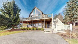 A two-story house with a balcony, a front porch, and a driveway. - 5BR - Chalet - Hot Tub (McHenry)