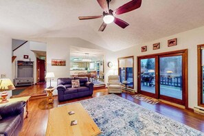 A living room with a ceiling fan, a sofa, a coffee table, and a rug. - Charming 4BR Lodge - HOT TUB - Swanton (Swanton)