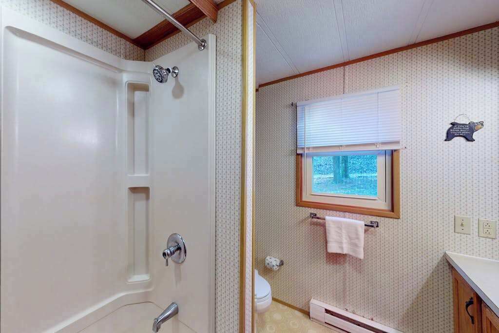 A bathroom with a shower, toilet, and sink.