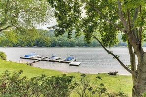 Ein Steg am See mit Booten und einer Rasenfläche.