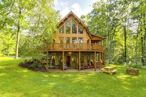 Eine Holzhütte mit Balkon, umgeben von einem üppigen grünen Wald.