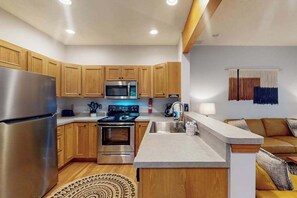 Una cucina moderna con mobili in legno, elettrodomestici in acciaio inossidabile e un'isola integrata.