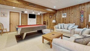 A room with a pool table, a sofa, and wooden paneling. - Rustic 3BR Cabin - HOT TUB - Oakland (Oakland)