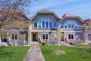 A two-story residential building with a central entrance, a small porch, and a well-maintained lawn. - Charming 3BR Townhouse - LAKE VIEW - McHenry (McHenry)