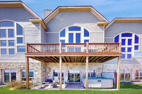A two-story house with a balcony, a hot tub, and a stone foundation.. Charming 3BR Townhouse - LAKE VIEW - McHenry