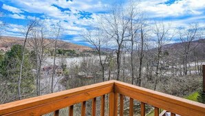 Eine Holzterrasse mit Blick auf einen Fluss und Berge.
