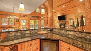 Ein Holzhütten-Interieur mit Kücheninsel, Holzausstattung und Kamin.