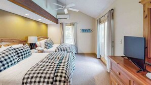 Une chambre d’hôtel avec deux lits, un ventilateur de plafond, un appareil de climatisation, une télévision et un panneau indiquant l’emplacement de la chambre.
