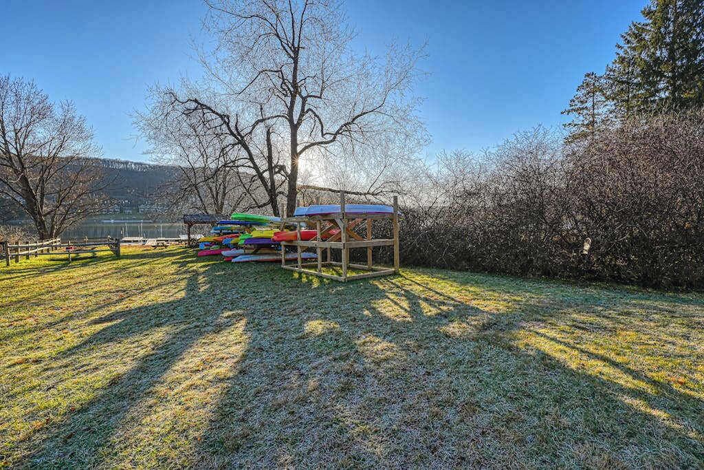 A wooden deck with colorful play equipment, a bench, and a small structure with a roof.