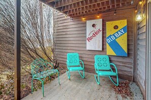A wooden exterior wall with two turquoise metal chairs and a red and blue sign. - 3BR - Lakeside Retreat - Pool (McHenry)