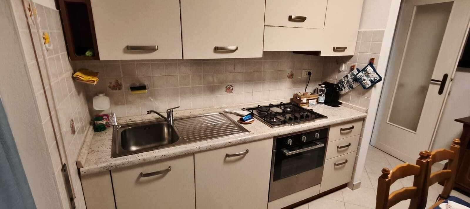 A compact kitchen with a gas stove, oven, and a sink.