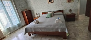 A bedroom with a bed, a dresser, a nightstand, and a window. - Sanremo Note di Mare: Relax & Comfort Apartment, a 10-meter walk from downtown  (Sanremo)