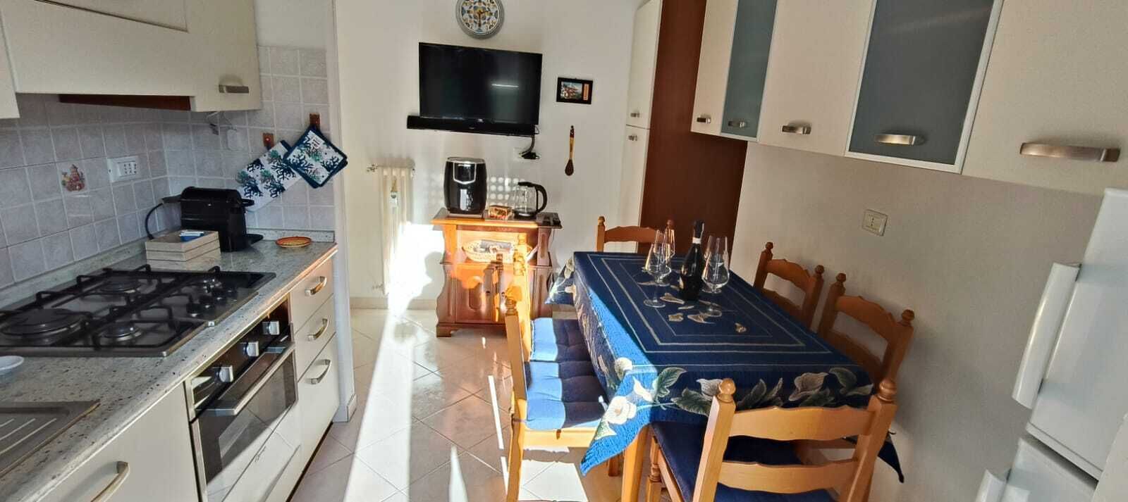 Una cucina compatta con piano cottura a gas, forno e tavolo da pranzo per quattro persone.