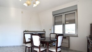 Ein Essbereich mit Tisch und Stühlen, einem eingebauten Herd und einem Fenster mit Jalousien.