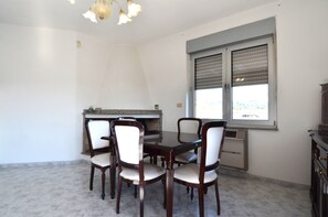 A dining area with a table and chairs, a built-in stove, and a window with blinds. - Fst-jav01p1 in San Teodoro (San Teodoro)