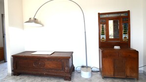 Ein Holzkabinett mit Spiegel, ein Schreibtisch mit Lampe und eine Wand mit dekorativem Schild.