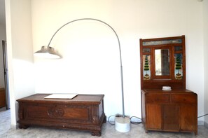 A wooden cabinet with a mirror, a desk with a lamp, and a wall with a decorative sign. - Fst-jav01p1 in San Teodoro (San Teodoro)
