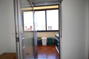 A kitchen with a window, a trash bin, and a refrigerator. - Fst-jav01p1 in San Teodoro (San Teodoro)