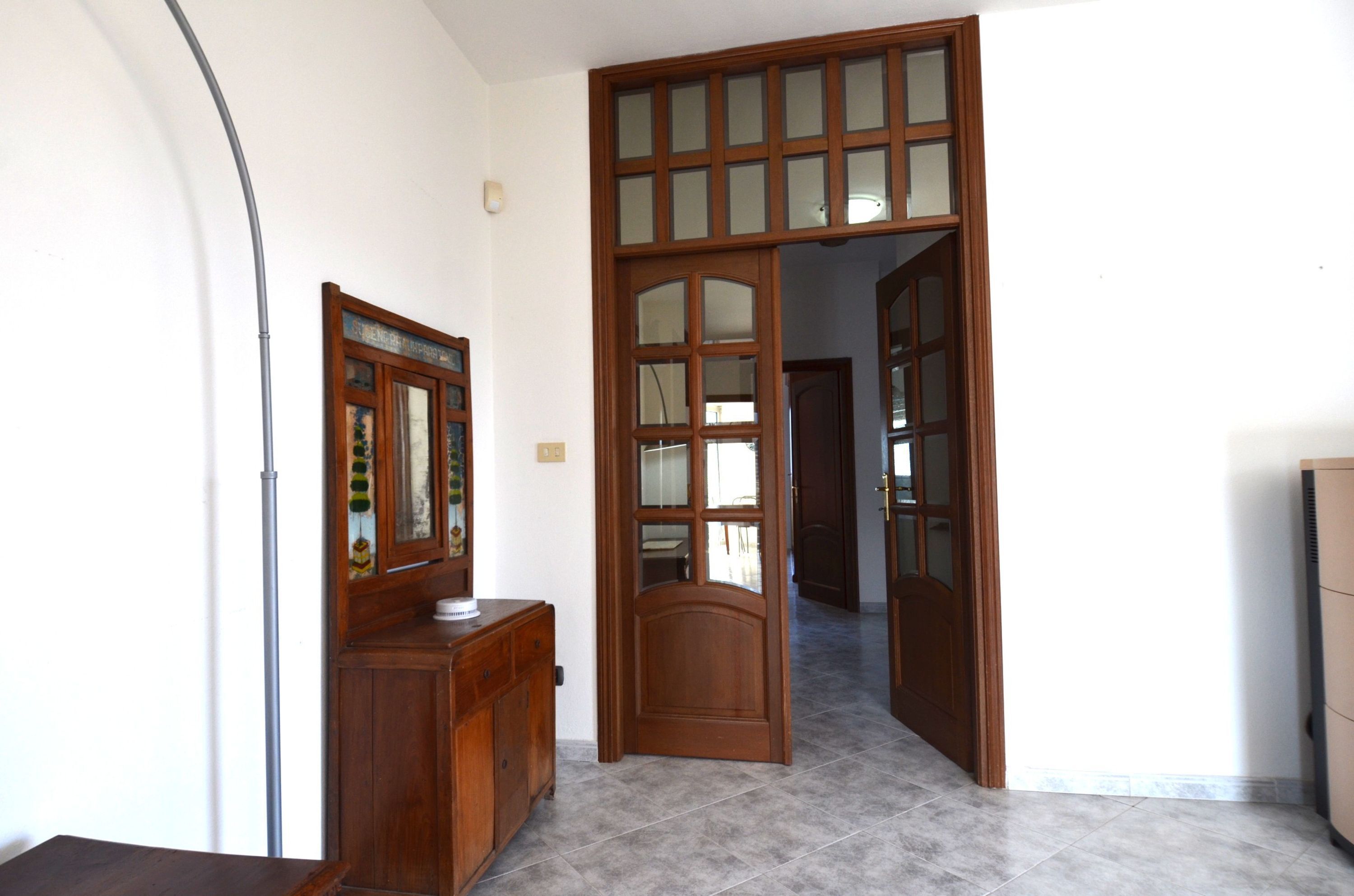 A room with a wooden door, a cabinet, and a tiled floor.