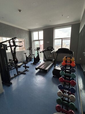 A gym with exercise equipment, a treadmill, and a rack of dumbbells. - Hotel/Apartment in Perdizes near PUC and Allianz Park - Room 407 (São Paulo)