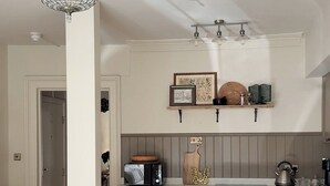 Uma cozinha moderna com lustre, armários de madeira e um espaço de refeições com mesa e cadeiras.
