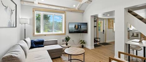 Una sala de estar moderna con un sofá, una mesa de centro y un televisor.