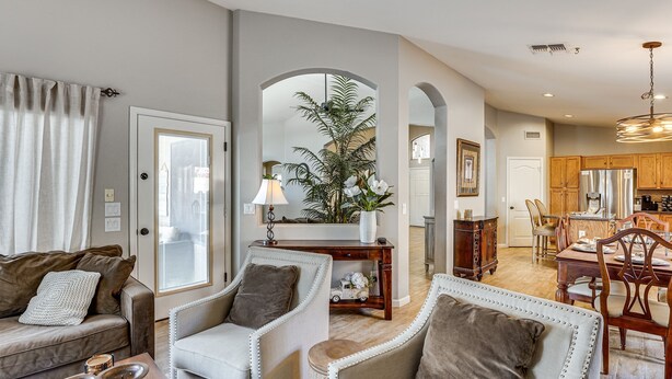 Ein Wohnzimmer mit Sofa, Sesseln, einem Couchtisch und einem Essbereich mit Tisch und Stühlen.