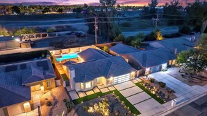 Zona residencial con casas, una piscina y un camino de entrada bien iluminado.