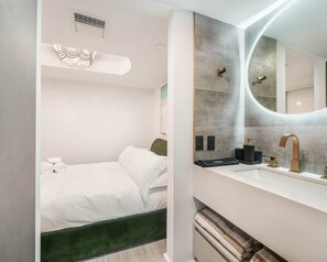 Ein modernes Hotelzimmer mit einem Bett, einem Frisiertisch mit Spiegel und einer Wand in Grüntönen.