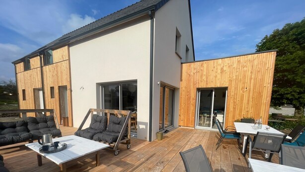 A modern outdoor deck with a sofa, chairs, and a table. - La maison des plages sleeps 14 (Erquy)