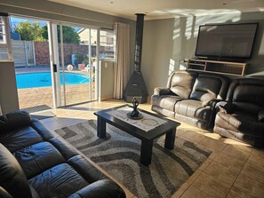 Una sala de estar con un sofá, una mesa de centro, una chimenea y un televisor.