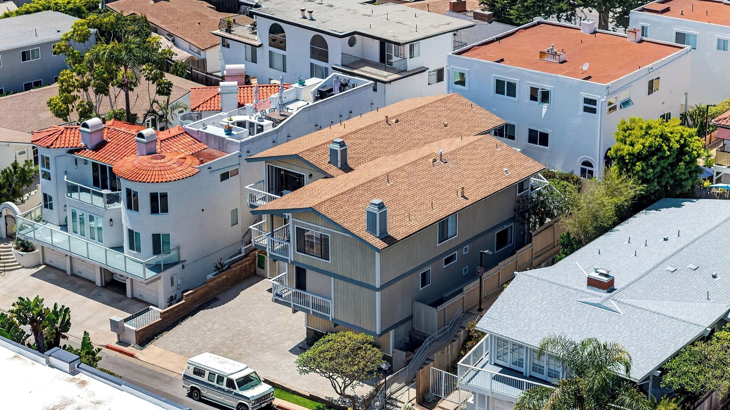 Un edificio residenziale a più piani con tetto piatto, numerosi balconi e un garage.