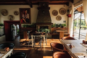 Un'accogliente zona pranzo con camino, mobili in legno e piatti decorativi alle pareti.