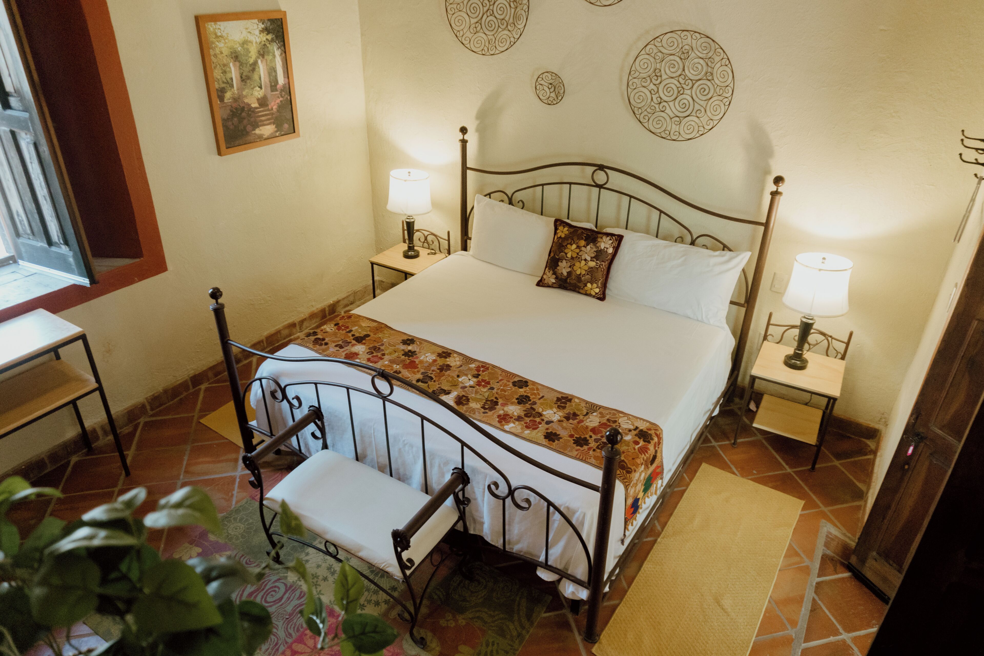 A neatly arranged bedroom with a bed, bedside tables, and a chair.