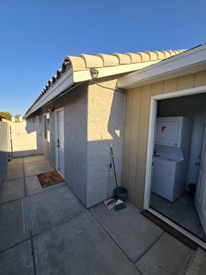 Ein Wohngebäude mit Ziegeldach, einem Hauswirtschaftsraum mit Waschmaschine und einer Tür zu einer Garage.