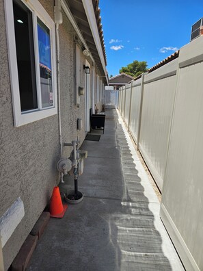 Ein Gebäude mit einem Betonweg, einem Metall-Feuerhydranten und einem weißen Zaun.