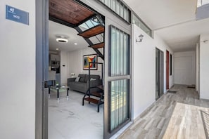 Ein modernes Interieur mit Treppe, einer Couch, einem Couchtisch und einer Küchenzeile.