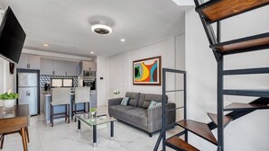 En moderne stue med sofa, sofabord og fjernsyn.